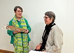 Die Autorin während der Lesung und mit ihrer Frau Monika Schmelter (links), die im Auftrag der Akademie Gegenwart ein Präsent überreichte.